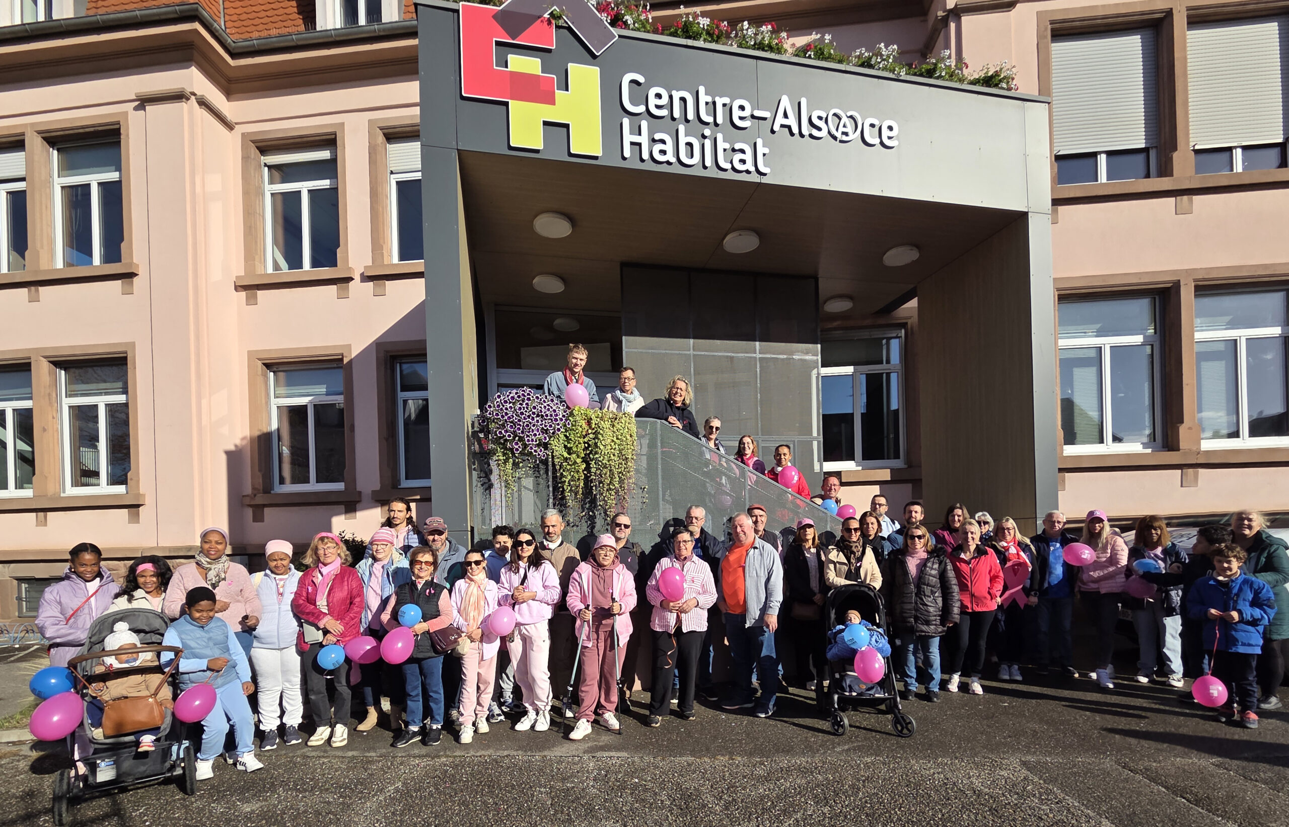 Locataires et salariés de Centre-Alsace Habitat posant en rose et en bleu {{brizy_dc_image_alt imageSrc=